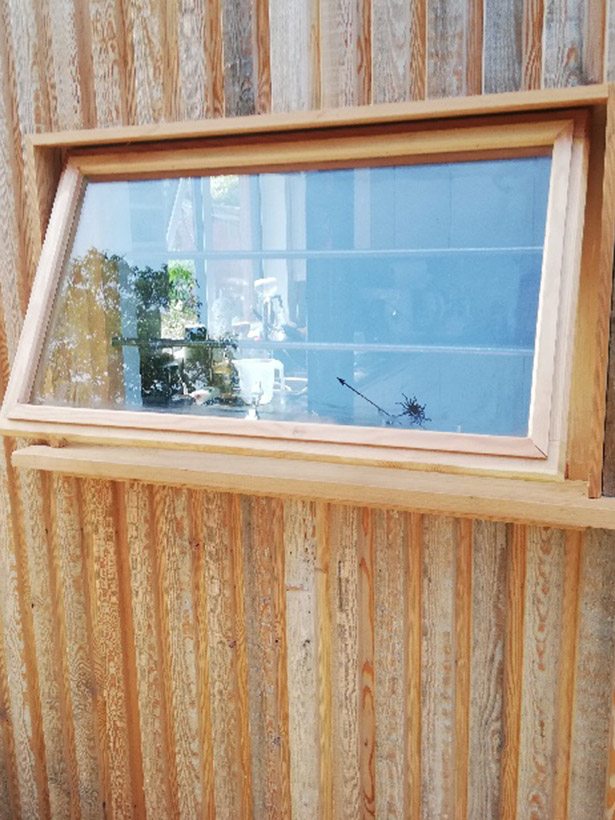 Exterior wooden single window frame with glass window.