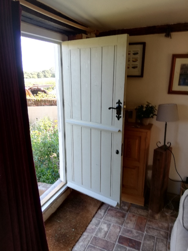 Exterior white wooden front door with black metal handle.