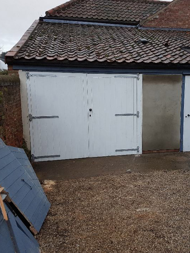 Double white wooden garage ('barn style') doors.