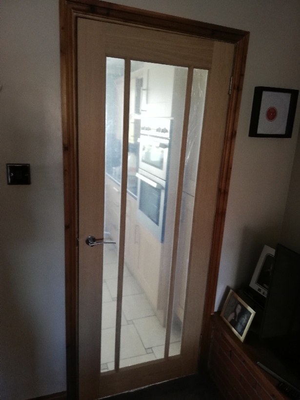 Interior wooden door with one large glass window.