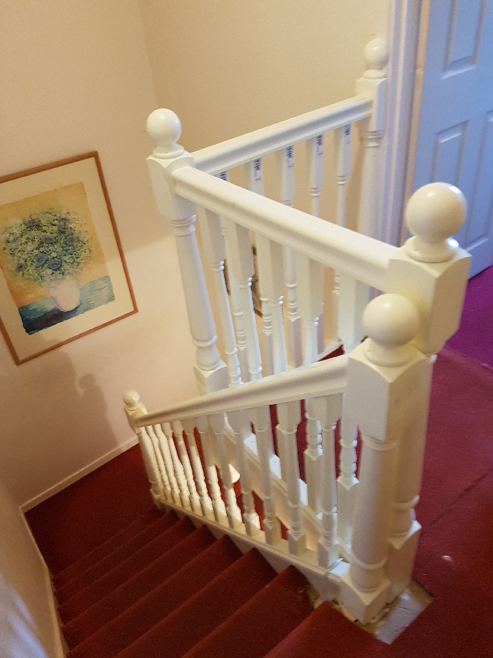White banisters with decorative spindles on two-level stairs.